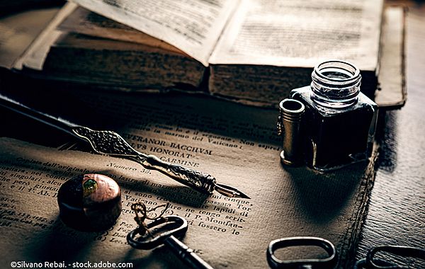 Nostalgisches Stilleben mit Schreibfeder, Tintenfass und Buch