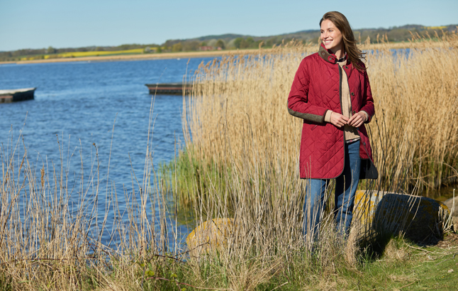 Frau am See in neuer Steppjacke