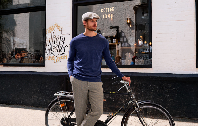 Mann mit Fahrrad vor Ladenzeile