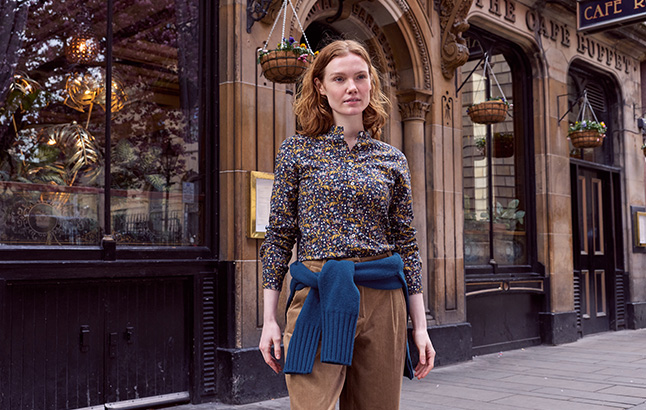 Frau vor Ladenzeile in Liberty-Bluse