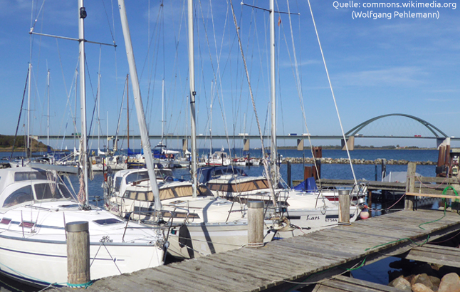 Fehmarnsundbrücke im Hintergrund und Segelboote im Hafen