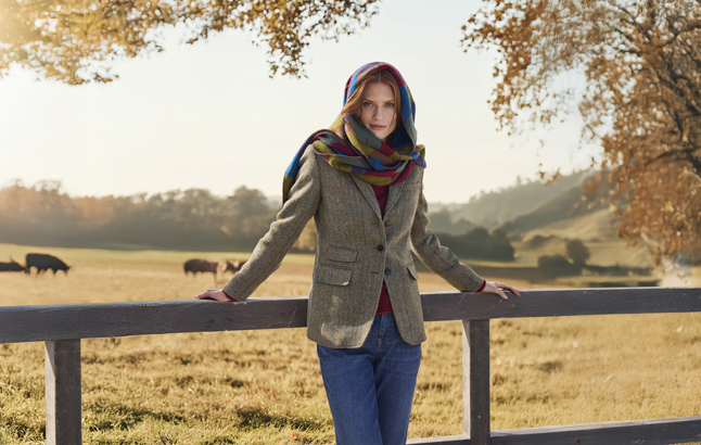 Frau lehnt an Weidengatter