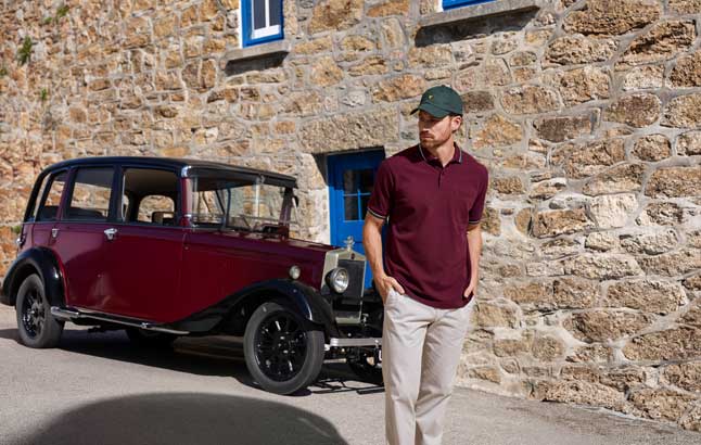 Mann vor Oldtimer im Poloshirt