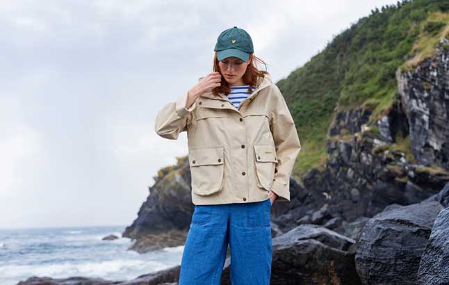 Frau im Barbour-Jacket auf Steilküste