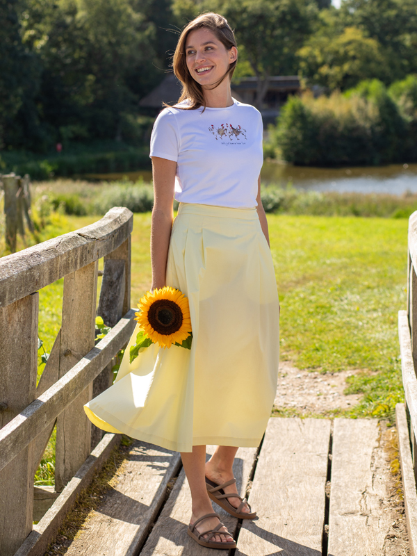 Pastellgelber Rock mit weißem Shirt kombiniert