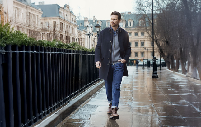 Mann schlendert auf nasser Straße