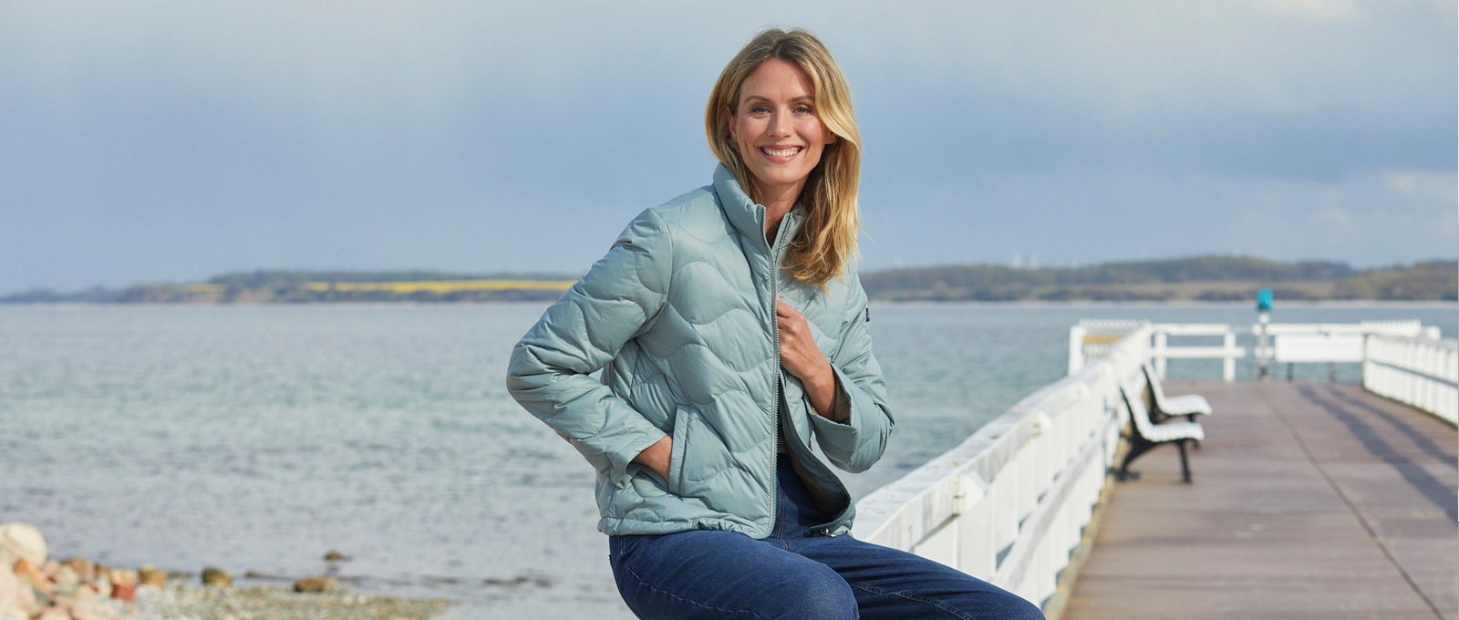 Frau mit Eisblauer Steppjacke am Meer