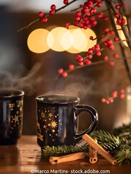 Stimmungsvoll: Becher mit Glühwein unter Beerenzweig