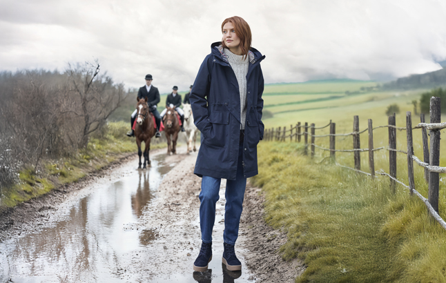 Frau auf Weg, Reiter im Hintergrund