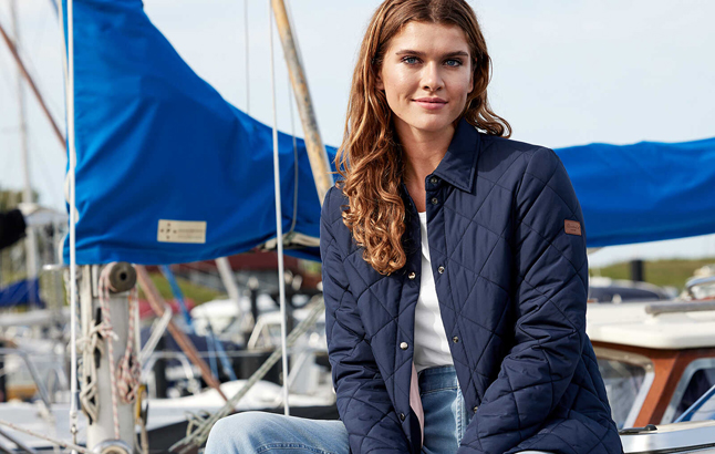 Frau im Hafen mit Barbour-Steppjacke