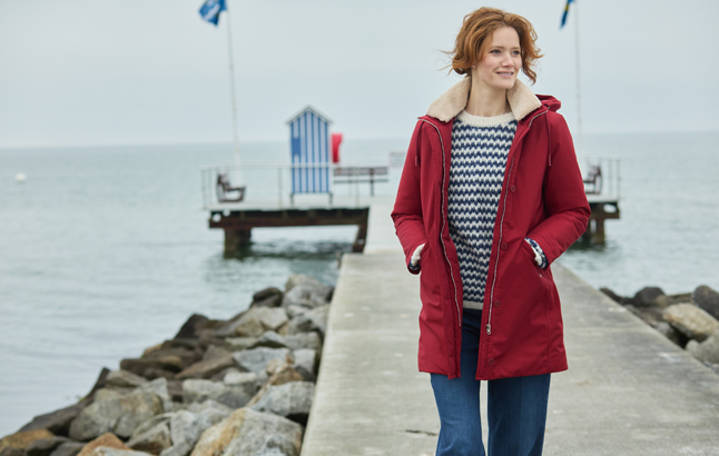 Frau im roten Parka auf Mole